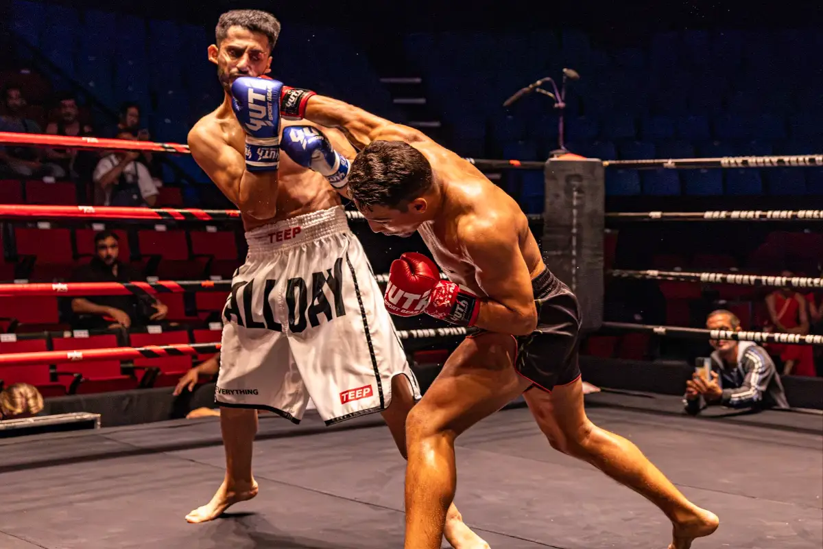 A fighter drives forward with a punch to the body