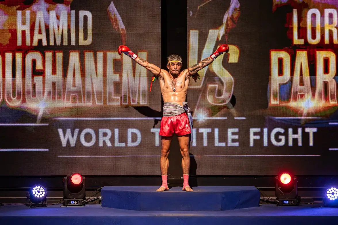 A fighter raises both gloves on the walkout stage under the IFL-5 world title fight screen